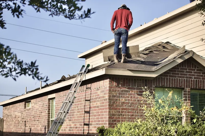 Professional roofer working on a residential roof in Columbine Hills